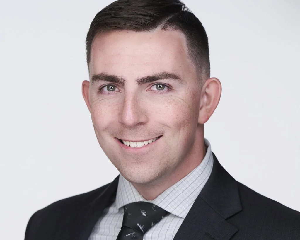 LinkedIn headshot of a man in a dark suit